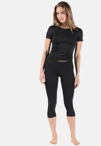 Black fitted short-sleeve shirt and ankle-length leggings made of smooth, stretchy fabric, featuring a sleek design and no visible patterns.