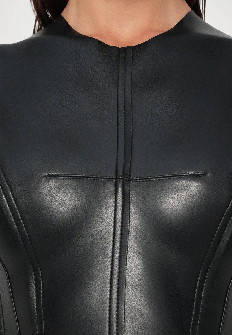Black leather garment with a high neckline, featuring sleek stitching and a minimalist design. Smooth texture and form-fitting shape.