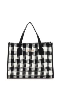 Sac fourre-tout à damier noir et blanc avec une texture tissée, des accents en cuir noir, des poignées doubles et un logo à l'avant.
