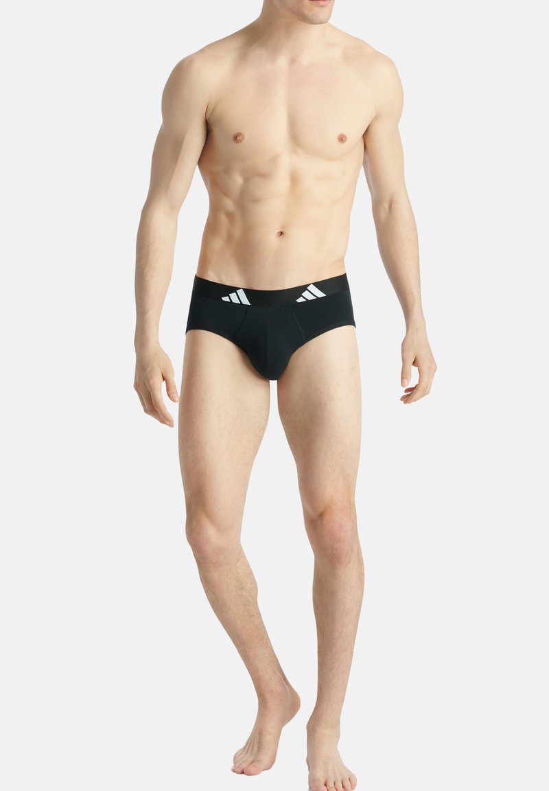 Schwarze Herrenunterwäsche mit weißen Akzentstreifen am Bund, ausgestattet mit einem enganliegenden Design und glatter Stofftextur.