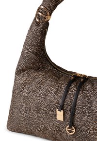 Bolso estilo hobo fabricado con un tejido estampado en negro y beige, que presenta herrajes en tono dorado, un cierre con cremallera y detalles en cuero.