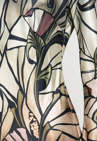 Αμάνικο φόρεμα με λουλουδάτο σχέδιο σε μπεζ, μαύρο και απαλά χρώματα. Λείο ύφασμα με εφαρμοστή σιλουέτα και καμπύλη γραμμή.