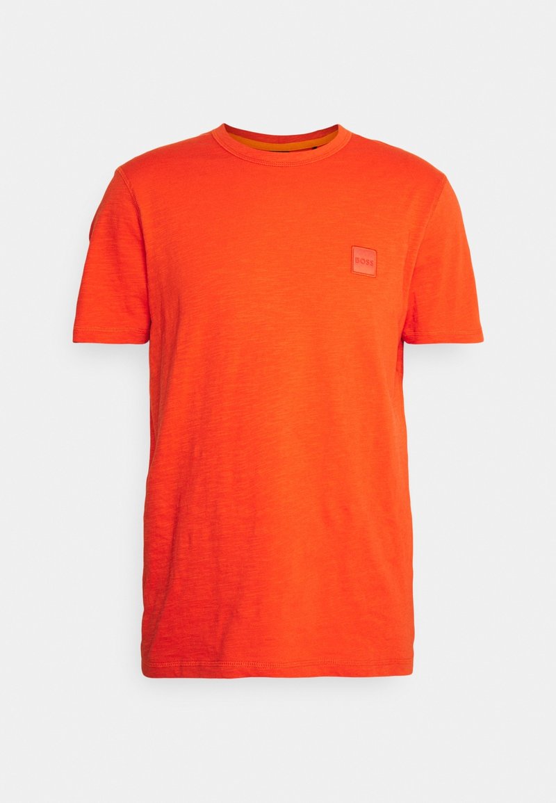 T-shirt orange vif à manches courtes et col rond avec un petit patch logo carré sur la poitrine gauche.