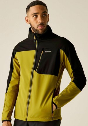 Hombre con chaqueta Regatta Great Outdoors verde y negra con cremalleras en el pecho y bolsillos para las manos, mirando hacia un lado.