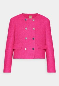 Veste courte rose vif texturée avec manches longues, col rond, double rangée de boutons argentés et deux poches avant à rabat.