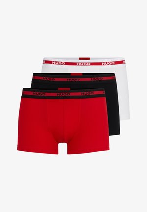 Drie paar Hugo herenboxershorts: één rood, één zwart en één wit, elk met een zwarte tailleband met het Hugo-logo in het rood.
