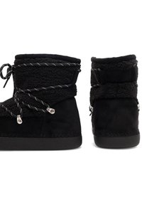 Fekete suede bokacsizmák műszőrme béléssel, texturált díszítéssel, fekete és fehér fűzőkkel, valamint ezüst színű kiegészítőkkel.