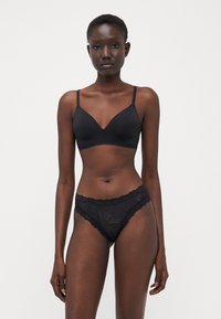 Black lingerie set featuring a smooth, padded triangle bra with thin straps and matching lace thong with scalloped edges and floral patterns.