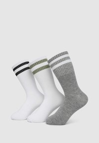 Trzy pary skarpetek: gładkie białe, szare w białe paski oraz oliwkowe w czarne paski. Wszystkie mają prążkowane mankiety i gładką teksturę.