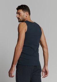 Marineblauw mouwloos tanktop van een gladde, rekbare stof. Heeft een ronde hals en een slim fit, en toont een schoon, minimalistisch ontwerp.