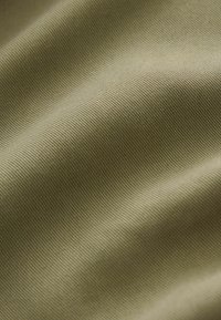 Textuurstof in olijfgroen, met fijn geweven strepen en zachte rondingen, met een zachte, gladde oppervlakte.