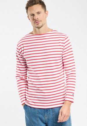 Chemise à manches longues rayée avec des lignes horizontales rouges et blanches, encolure ronde, et un petit accent de logo bleu sur la manche.