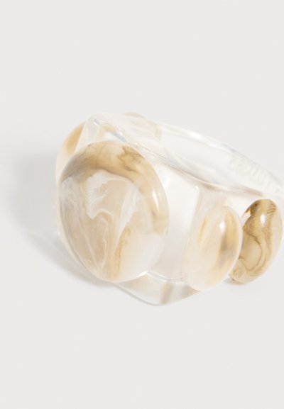 Καθαρό ρητινώδες δαχτυλίδι με τρεις μεγάλους οβάλ λίθους σε μπεζ και λευκό μαρμάρινο μοτίβο, τοποθετημένους στην κορυφή, παρουσιάζεται σε λευκό φόντο.