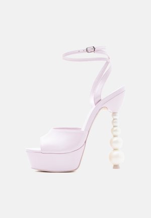 Lavendelkleurige sandalen met hoge hak en plateauzool, enkelbandje en een uniek ontwerp van kralenbollen op de hak tegen een witte achtergrond.