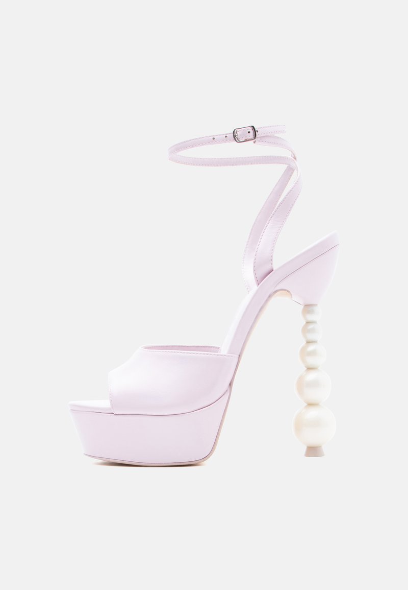Lavendelfarvet højhælet sandal med plateau-sål, ankelsnor og et unikt design med perlebesatte kugler på hælen mod en hvid baggrund.