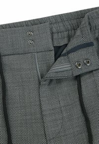 Gray patterned shorts featuring a drawstring, button closure, and zippered pocket. Textured fabric with a modern design.