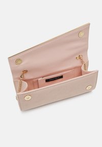 Liten rosa plånbok med en strukturerad yta, utrustad med detaljer i guld, en kedja som axelrem och flera fack för kort och kontanter inuti.