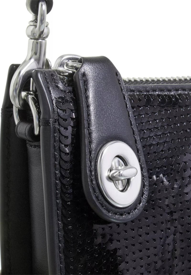 Schwarze handgefertigte Clutch mit glattem Ledertrageriemen, silberner Hardware und einer dekorativen Druckknopfschließe. Kompakt und mit einem schönen Texturkontrast.