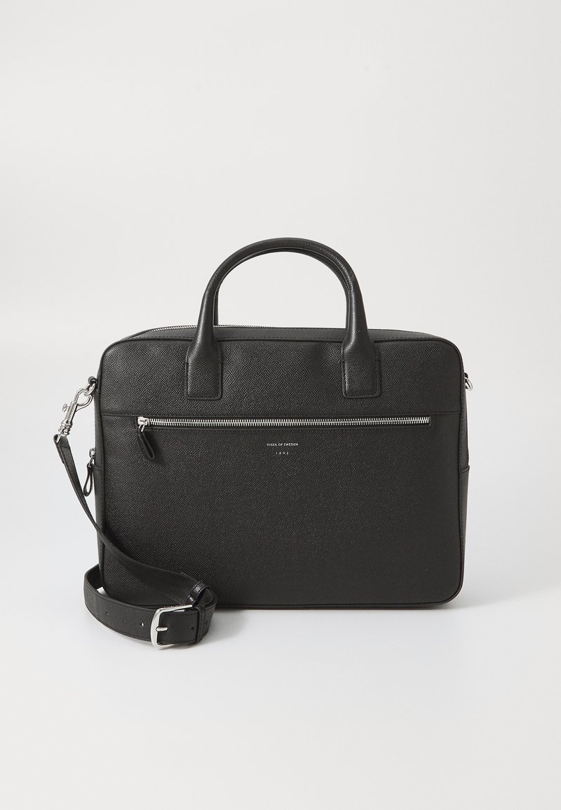 Black leather briefcase with smooth texture, two top handles, and a detachable shoulder strap. Features a zippered front pocket.