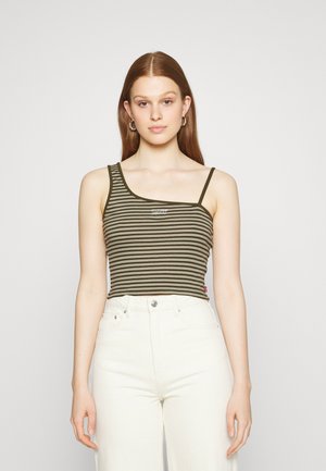 Camisola de alças às riscas em verde-oliva e creme, com uma única alça e detalhe de logo, combinada com jeans brancos de cintura alta.