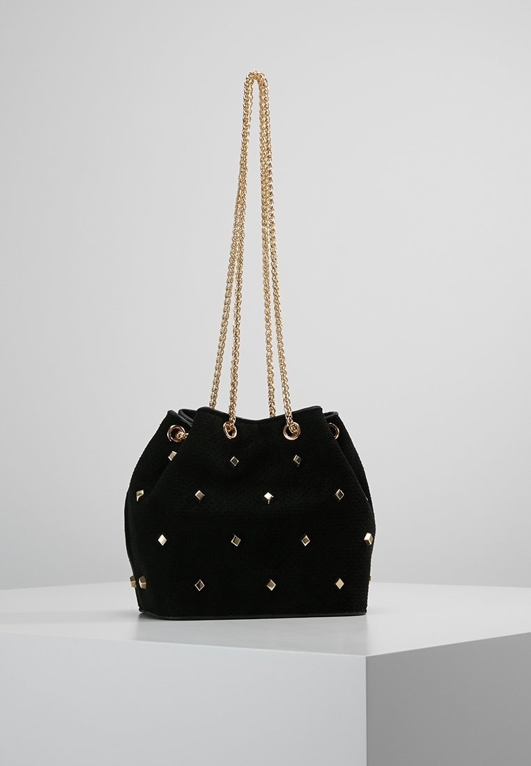 Borsa a secchiello in suede nero con borchie a diamante dorate, dotata di doppia tracolla a catena e chiusura a coulisse. Texture morbida, forma arrotondata.