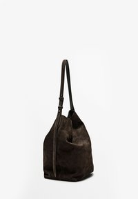 Brun ruskinds bucketbag med en enkelt justerbar læderrem og en rund bund. Teksturen er blød, med glatte sømme og et minimalistisk design.