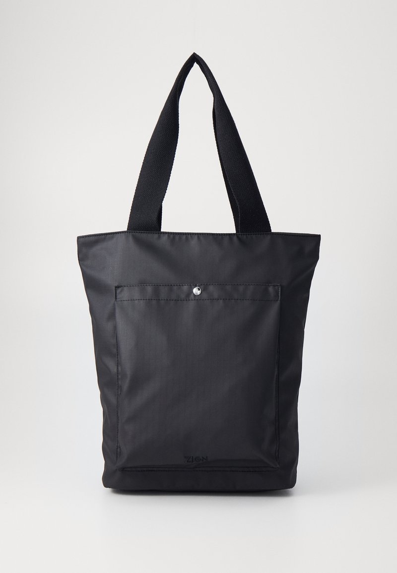 Black tote bag made of sleek fabric, featuring two sturdy handles, a front pocket with a snap closure, and a minimalist design.