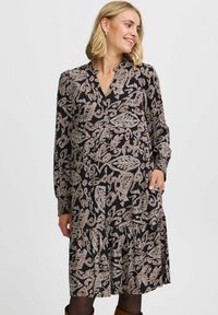 Rochie neagră cu mâneci lungi, decolteu în V și model floral în nuanțe de bej. Dispune de o fustă în straturi și buzunare laterale. Textura fabricii este moale.
