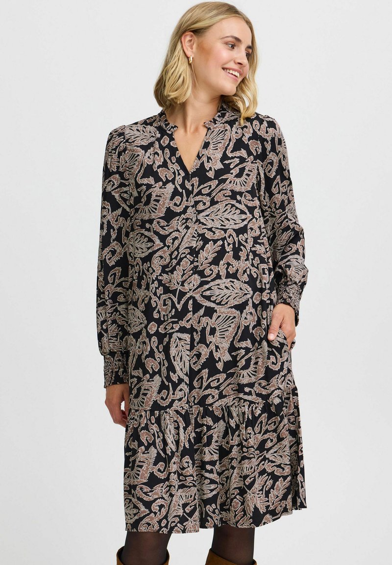 Rochie neagră cu mâneci lungi, decolteu în V și model floral în nuanțe de bej. Dispune de o fustă în straturi și buzunare laterale. Textura fabricii este moale.