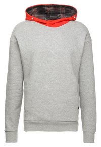 Grå sweatshirt med röd huva och svart rutmönstrad foder. Har en avslappnad passform, ribbad manschetter och nederkant. Knappar pryder huvaöppningen.