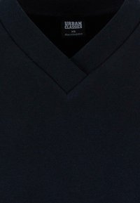 Felpa con scollo a V di colore blu navy scuro; tessuto in misto cotone con colletto a costine. Etichetta con la scritta "URBAN CLASSICS," misura XS, prodotta in Bangladesh.