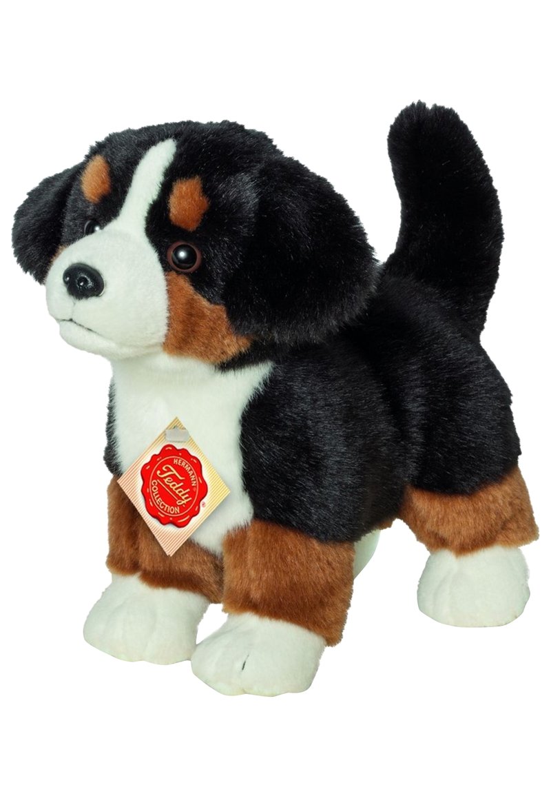Plush dog toy featuring black, brown, and white fur, realistic facial details, and a hanging tag. Stands upright with a soft texture.