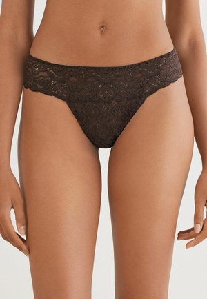 Zwarte kanten stringonderbroek met een gekartelde kanten rand, complexe bloempatronen en een zachte textuur, met een minimalistisch dekking ontwerp.