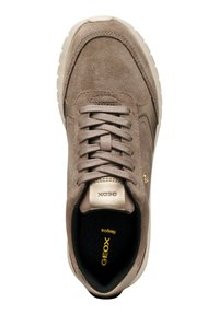 Zapatilla de gamuza marrón con superficie texturizada, punta redonda, detalles dorados, lengüeta acolchada y plantilla negra con "GEOX" en amarillo.
