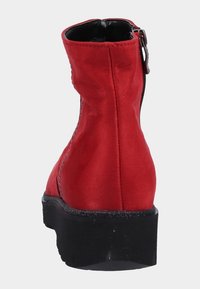 Röda konstläder anklar stövlar med rund tå, svart gummisula och en innerdragkedja. Har stickade detaljer längs sidorna.