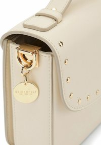 Sac à épaule en cuir beige avec quincaillerie dorée, y compris un fermoir et une étiquette logo. Présente des clous décoratifs le long du bord pour le détail.