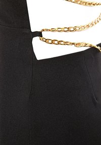 Robe noire avec un design découpé, texture lisse et une chaîne dorée décorative accentuant la taille.