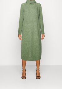 Langärmliges, grünes Strickkleid mit hohem Kragen und gerippten Akzenten, das eine gerade Silhouette und ein knielanges Design aufweist.