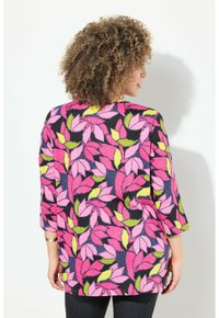 Färgglad topp med en svart bakgrund och livliga mönster av rosa och gröna blad. Trekvartslånga ärmar och en avslappnad passform.