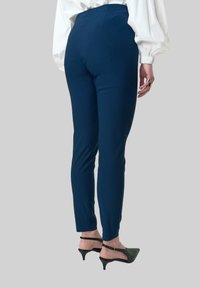 Navyblauwe, rekbare broek met een slanke pasvorm, hoge taille en een gladde textuur. Heeft een strak ontwerp zonder zichtbare sluitingen.