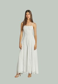 Weißes Maxikleid mit tailliertem Oberteil, Spaghettiträgern und fließendem Rock. Hergestellt aus leichtem Stoff mit glatter Textur.