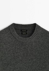 Pull en maille gris avec un col rond côtelé, doté d'une texture douce et d'un design minimaliste. Étiquettes affichées à l'intérieur du col.
