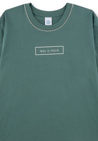 Groene katoenen t-shirt met een ronde hals, korte mouwen en de tekst "less is more" in een witte rechthoekige doos op de voorkant.