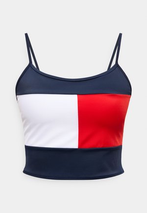 Μπλε σκούρο κοντό τοπ με λεπτές τιράντες, που διαθέτει οριζόντια τριχρωμία σε λευκό, κόκκινο και μπλε σκούρο στο στήθος.