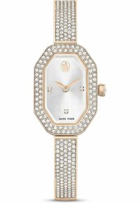 Ośmiokątny zegarek z srebrną tarczą, różowo-złotymi akcentami oraz lśniącymi kryształkami na obrzeżu i bransoletce, które nadają mu błyszczący efekt.