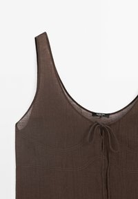 Haut marron sans manches avec un col rond et un détail de nœud à l'avant, en tissu léger semi-transparent avec des coutures visibles.