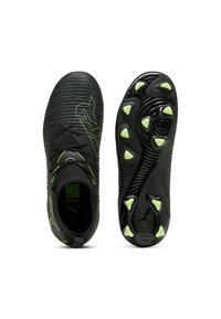 Botas de fútbol negras con parte superior texturizada y acentos en verde neón. Presenta un diseño elegante, cierre con cordones y un patrón de tacos distintivo en la suela.