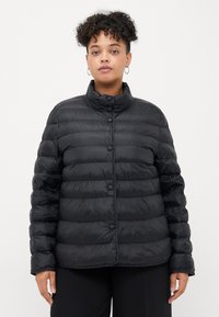 Čierna puffer bunda s horizont�álnym prešívaním, vysokým golierom a predným zapínaním na gombíky. Hladký, lesklý povrch; ľahký materiál.