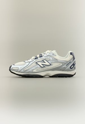 Chaussure de running New Balance 204L blanche et grise avec panneaux en mesh, lacets et semelle en caoutchouc noire, vue de profil sur un fond neutre.