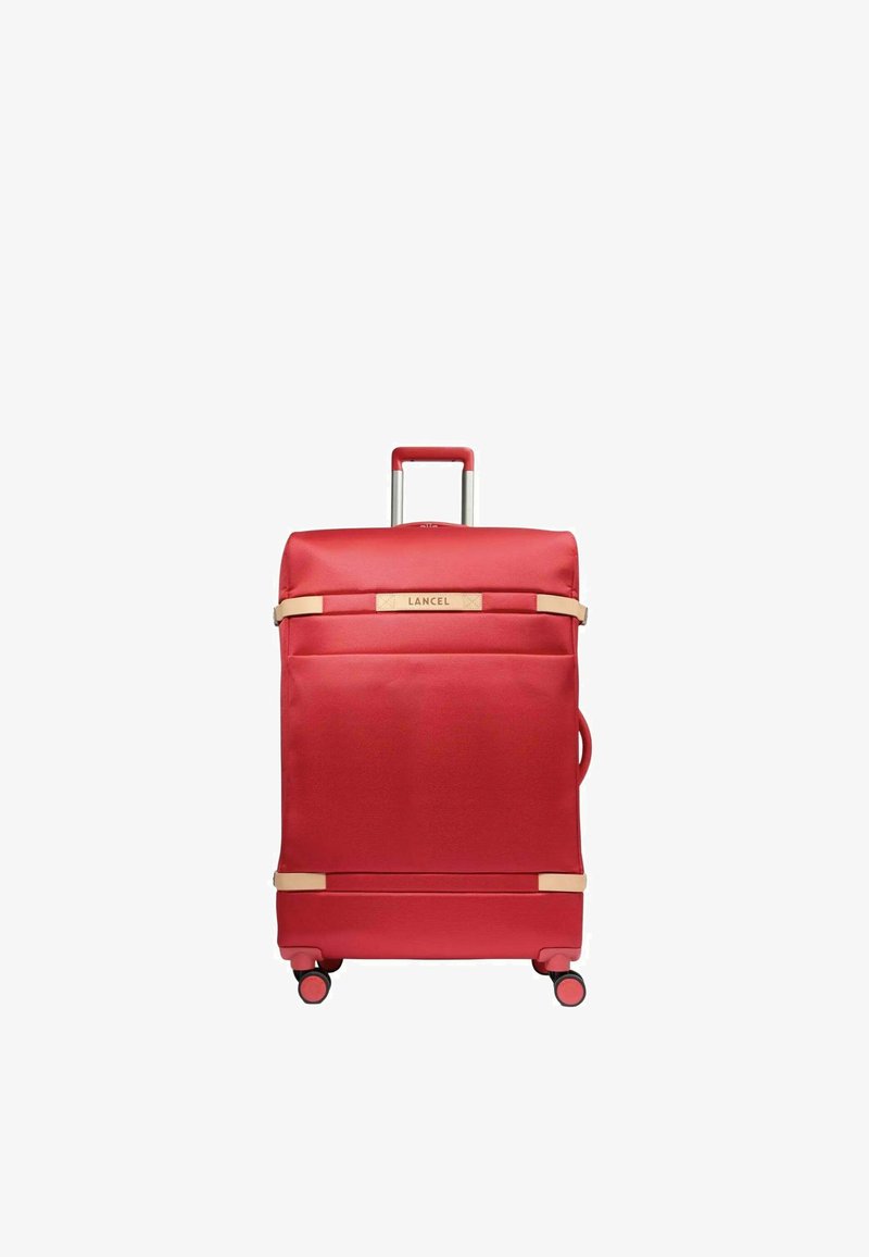 Valise à roulettes souple rouge avec une poignée téléscopique, quatre roues, des sangles beiges et le logo "Lancel" à l'avant.